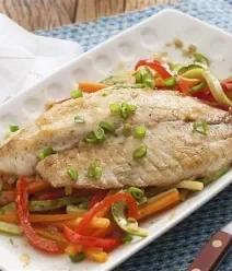 Receitas Incríveis Gastando Pouco Fotografia de um filé de peixe sobre uma cama de vegetais refogados em um prato branco retangular.
