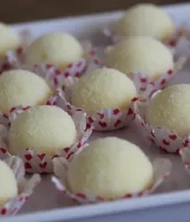 Fotografia mostra brigadeiros de leite ninho enrolados e servidos em forminhas Fotografia mostra brigadeiros de leite ninho enrolados e servidos em forminhas
