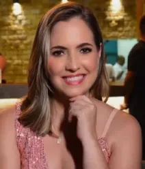 Fotografia mostra uma mulher com a mão no queixo e sorrindo. Fotografia mostra uma mulher com a mão no queixo e sorrindo.