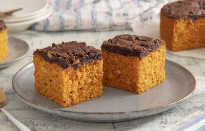 imagem mostra fatias de bolo de cenoura com uma camada de brownie de chocolate por cima.