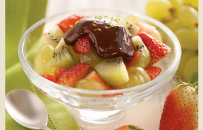 fotografia em tons de verde, contém uma taça transparente com pedaços de morangos, kiwis e ganache por cima fotografia em tons de verde, contém uma taça transparente com pedaços de morangos, kiwis e ganache por cima