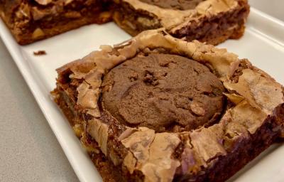 Fotografia mostra um brownie de chocolate com um cookie de chocolate em cima. Fotografia mostra um brownie de chocolate com um cookie de chocolate em cima.