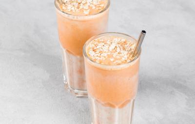 Fotografia de dois copos de vidro com um suco de pitanga com melaço de cana. Dentro dos copos com o suco, um canudo de metal, e embaixo dos copos, uma mesa cinza em tom claro. Fotografia de dois copos de vidro com um suco de pitanga com melaço de cana. Dentro dos copos com o suco, um canudo de metal, e embaixo dos copos, uma mesa cinza em tom claro.