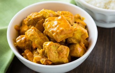 Fotografia de um frango em cubos temperado com molho de curry