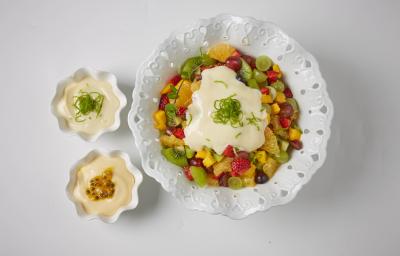 foto em tons de branco de uma bancada branca vista de cima, contém um recipiente redondo branco ao centro com pedaços de frutas e creme. Ao lado dois potinhos redondos brancos com creme. foto em tons de branco de uma bancada branca vista de cima, contém um recipiente redondo branco ao centro com pedaços de frutas e creme. Ao lado dois potinhos redondos brancos com creme.