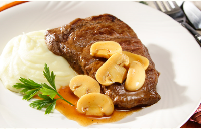 Fotografia em tons de branco e marrom, com bife com molho de champignons acompanhado de purê de batatas e ramo de salsa em prato branco, sobre sous plat marrom, ao lado guardanapo dobrado com garfo e faca por cima, tudo sobre toalha cinza. Fotografia em tons de branco e marrom, com bife com molho de champignons acompanhado de purê de batatas e ramo de salsa em prato branco, sobre sous plat marrom, ao lado guardanapo dobrado com garfo e faca por cima, tudo sobre toalha cinza.