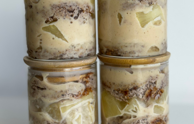 Fotografia mostra um pote transparente, dando visibilidade para o bolo, recheio e pedaços de abacaxi.