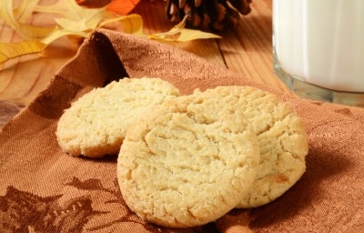 Em cima de uma mesa, pano de prato marrom com biscoitos redondos crocantes e dourados. Em cima de uma mesa, pano de prato marrom com biscoitos redondos crocantes e dourados.