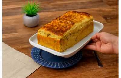 Fotografia em tons claros com um prato retangular branco ao centro. Em cima do prato existe uma receita de pão de forma caseiro sem farinha feito com batata doce e NINHO Adulto