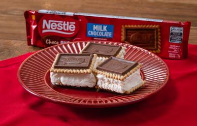 Fotografia em tons de vermelho com um prato vermelho ao centro. Em cima do prato existe 3 biscoitos Choco Biscuit recheados com sorvete de creme.