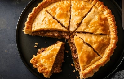 Torta dourada e crocante com massa rústica, recheio visível de carne moída suculenta, destacando-se no corte. Torta dourada e crocante com massa rústica, recheio visível de carne moída suculenta, destacando-se no corte.