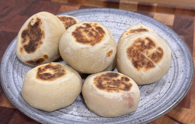 imagem mostra pequenos pãezinhos brancos e dourados sobre uma superfície
