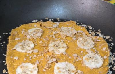Fototgrafia de uma omelete de neston com rodelas de banana e neston cereias polvilhado, sobre uma frigideira. Fototgrafia de uma omelete de neston com rodelas de banana e neston cereias polvilhado, sobre uma frigideira.