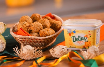 Bolinho de milho recheado com frango em cesta ao lado de pote de Margarina Deline