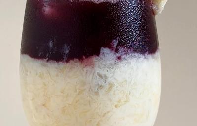 Fotografia em tons claros de uma taça de vidro com uma espanhola de abacaxi sem álcool.