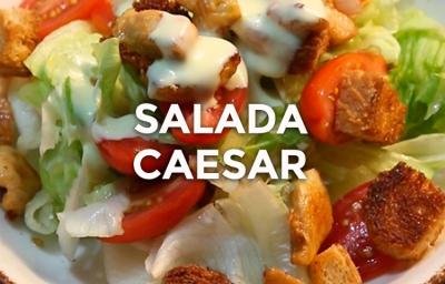Foto da receita de Salada Caeser. Observa-se um prato com alface americana, tomates cereja, crouton, frango e molho Foto da receita de Salada Caeser. Observa-se um prato com alface americana, tomates cereja, crouton, frango e molho