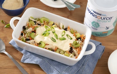 Fotografia mostra travessa com salpicão, visivelmente colorido com cenoura, salsão e uvas passas, com pedaços de frango, por cima o creme. Fotografia mostra travessa com salpicão, visivelmente colorido com cenoura, salsão e uvas passas, com pedaços de frango, por cima o creme.