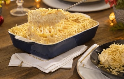 Travessa azul com fricassê de frango com milho e batata palha com uma colher tirando um pedaço. Travessa azul com fricassê de frango com milho e batata palha com uma colher tirando um pedaço.