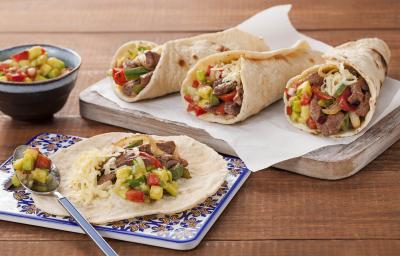 Em uma mesa de madeira contém duas tábuas, uma contem a fajita aberta e na outra de madeira contém três fechadas.