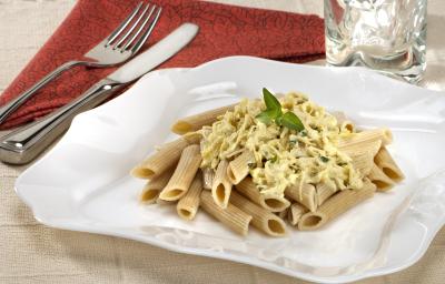 em um prato branco contém o macarrão. Ao lado, um pano na cor vermelha e por cima grafo e faca. em um prato branco contém o macarrão. Ao lado, um pano na cor vermelha e por cima grafo e faca.