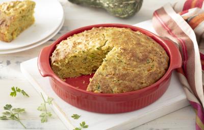 Foto da receita de Torta de Casca de Abóbora com Recheio de Talos. Observa-se a torta assada dentro de um recipiente refratário vermelho com um pedaço cortado Foto da receita de Torta de Casca de Abóbora com Recheio de Talos. Observa-se a torta assada dentro de um recipiente refratário vermelho com um pedaço cortado