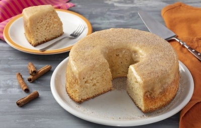 Prato branco com um bolo branco com cobertura de doce de leite sem lactose.