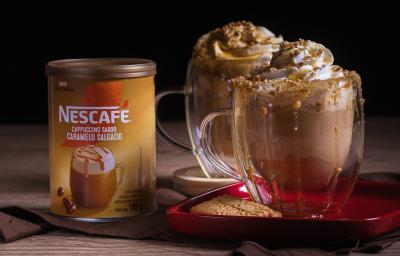 Foto da receita de cappuccino caramelo salgado servida em dois copos de vidro sobre uma mesa de madeira