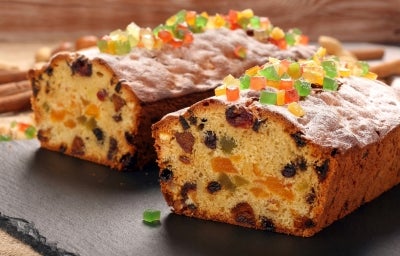 Fotografia de um bolo de frutas natalino, com uma camada generosa de frutas cristalizadas coloridas no topo. O bolo, cortado, revela um interior rico e vibrante. Fotografia de um bolo de frutas natalino, com uma camada generosa de frutas cristalizadas coloridas no topo. O bolo, cortado, revela um interior rico e vibrante.