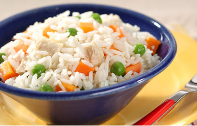fotografia em tons de amarelo, azul e branco tirada de um prato redondo amarelo com um recipiente azul, que contém o arroz com pedaços de cenouras e ervilhas com um garfo ao lado para servir fotografia em tons de amarelo, azul e branco tirada de um prato redondo amarelo com um recipiente azul, que contém o arroz com pedaços de cenouras e ervilhas com um garfo ao lado para servir