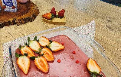 Foto da receita de Doce amor de morango. Observa-se uma travessa com o creme rosa e morangos frescos decorando. Foto da receita de Doce amor de morango. Observa-se uma travessa com o creme rosa e morangos frescos decorando.