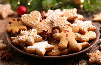 Em cima de uma mesa, prato redondo com biscoitos em formato de estrelas, decorados com açúcar de confeiteiro. Em cima de uma mesa, prato redondo com biscoitos em formato de estrelas, decorados com açúcar de confeiteiro.