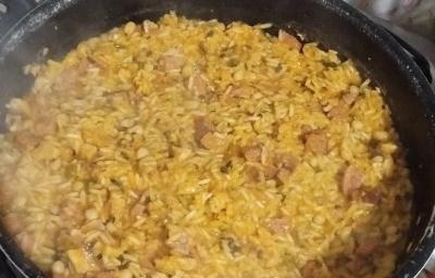 Fotografia de uma panela preta funda com uma receita de baião. Fotografia de uma panela preta funda com uma receita de baião.