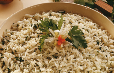 fotografia em tons de bege tirada de uma panela redonda bege com alças, que contém arroz e ervas dentro. fotografia em tons de bege tirada de uma panela redonda bege com alças, que contém arroz e ervas dentro.