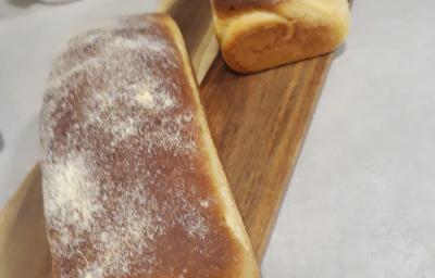 Fotografia de dois pães grandes de milho sobre uma tábua retangular de madeira. Fotografia de dois pães grandes de milho sobre uma tábua retangular de madeira.
