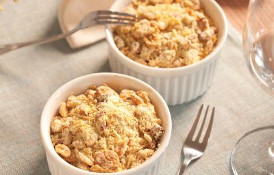 fotografia em tons de cinza, branco e bege de uma bancada cinza vista de cima, contém dois potes redondos e brancos com Crumble de Legumes e queijo ralado por cima, ao lado um garfo para servir. fotografia em tons de cinza, branco e bege de uma bancada cinza vista de cima, contém dois potes redondos e brancos com Crumble de Legumes e queijo ralado por cima, ao lado um garfo para servir.