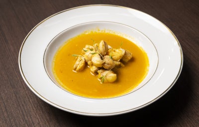 Peixe-sapo ao molho cremoso servidos em prato fundo, receita sofisticada com frutos do mar e apresentação elegante.