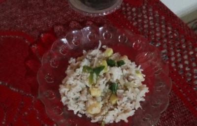Fotografia de um prato de vidro sobre um pano vermelho, dentro do prato tem arroz com lentilha e abobrinha. Fotografia de um prato de vidro sobre um pano vermelho, dentro do prato tem arroz com lentilha e abobrinha.