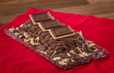 Fotografia de uma torta gelada de chocolate com chocolate derretido e alguns chocobiscuit por cima e ao lado. Fotografia de uma torta gelada de chocolate com chocolate derretido e alguns chocobiscuit por cima e ao lado.