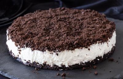 Fotografia de um sanduíche com base e topo de biscoito de chocolate triturado, recheado com creme branco. Fotografia de um sanduíche com base e topo de biscoito de chocolate triturado, recheado com creme branco.