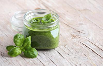fotografia em tons de bege e verde de uma bancada bege vista de frente. Contem um potinho com creme verde dentro. fotografia em tons de bege e verde de uma bancada bege vista de frente. Contem um potinho com creme verde dentro.