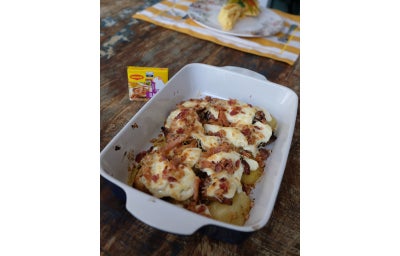 Travessa branca com sobrecoxas de frango coberto por requeijão cremoso Nestlé e bacon crocantes