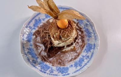 Fotografia em tons de branco com um prato azul ao centro. Em cima do prato existe uma receita de rabanada de panettone com uma bola de sorvete de creme em cima Fotografia em tons de branco com um prato azul ao centro. Em cima do prato existe uma receita de rabanada de panettone com uma bola de sorvete de creme em cima