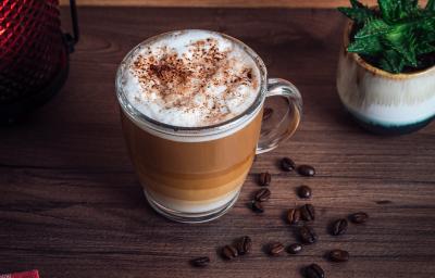 fotografia em tons de marrom e branco de uma bancada marrom vista de cima. Contém uma xicara transparente com café e por cima chantilly com raspas de chocolate. fotografia em tons de marrom e branco de uma bancada marrom vista de cima. Contém uma xicara transparente com café e por cima chantilly com raspas de chocolate.