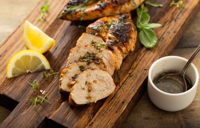 fotografia de um peito de frango servido com molho de ervas