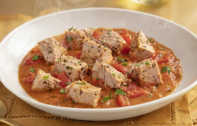 Goulash moderno de atum servido em prato fundo, com cubos de peixe em molho de tomate encorpado e ervas frescas.