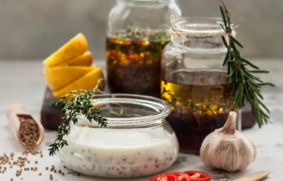 A imagem mostra três recipientes redondos, pequenos, de formatos variados, contendo misturas de temperos, marinadas e óleos