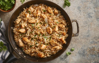 Fotografia de uma receita de arroz com frango feitos em uma panela de ferro
