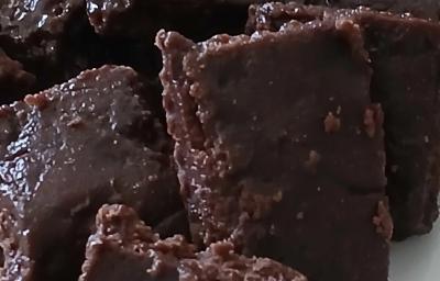 Fotografia de vários pedaços de um doce de corte com açaí, um sobre o outro.