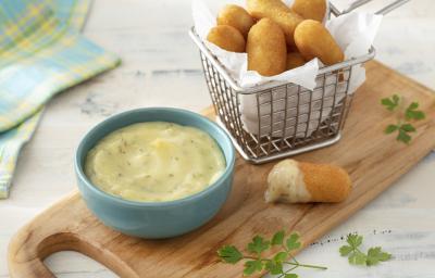 Foto da receita de Molho de Alho com Biomassa de Banana Verde. Observa-se um potinho azul com o molho e ao lado uma cestinha de bolinho de mandioca frito com papel toalha Foto da receita de Molho de Alho com Biomassa de Banana Verde. Observa-se um potinho azul com o molho e ao lado uma cestinha de bolinho de mandioca frito com papel toalha