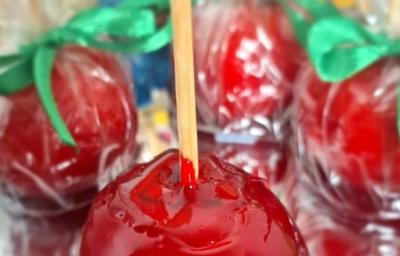 Fotografia de algumas porções de beijinho do amor. A porção da frente está com um palitinho, mas as do fundo estão dentro do saquinho fechado. Fotografia de algumas porções de beijinho do amor. A porção da frente está com um palitinho, mas as do fundo estão dentro do saquinho fechado.